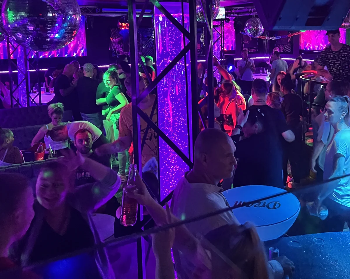 Feiernde Gäste und farbiges Licht in einem Club