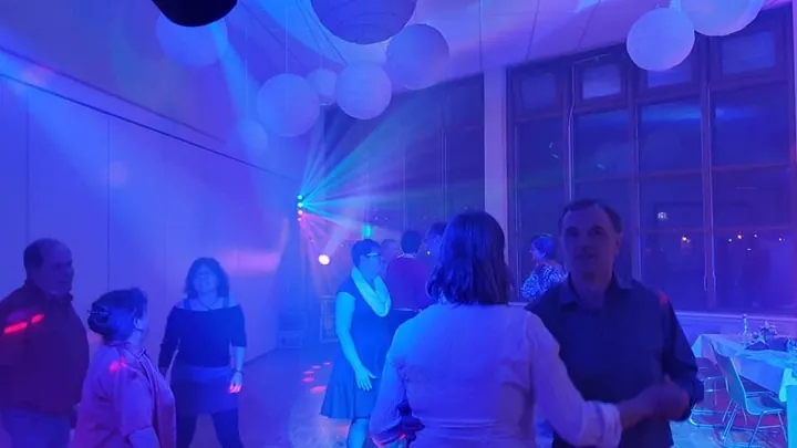 Tanzende Gäste bei einer Feier mit blauem Licht