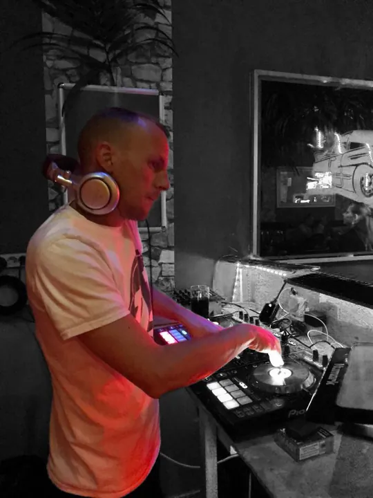 DJ Ramón mit Kopfhörern bei der Arbeit an seinem DJ-Pult