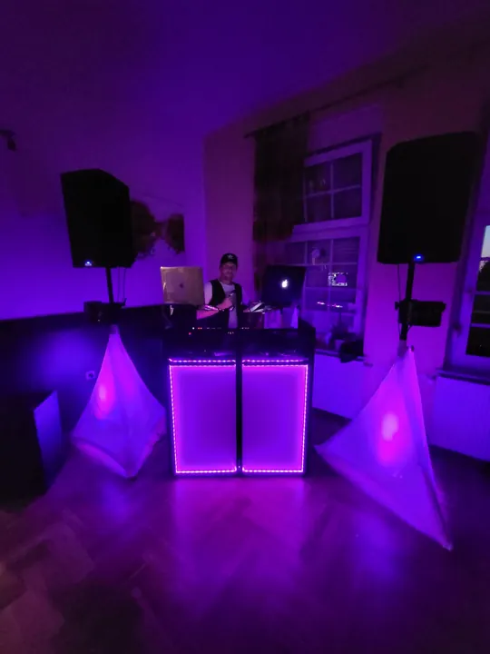 Ramón hinter seinem violett beleuchteten DJ-Pult