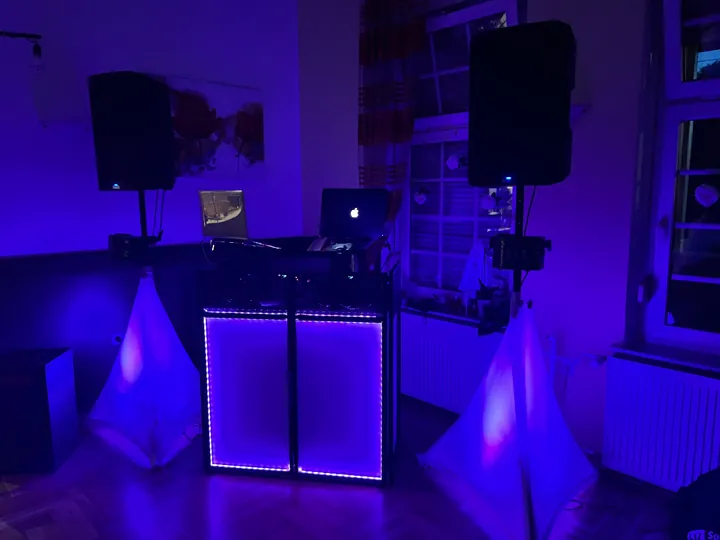 DJ-Pult und Lautsprecher mit violetter indirekter Beleuchtung